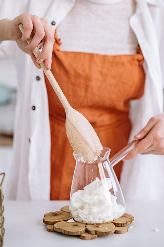 The Art of Drawing Readers In: Your attractive post title goes here Close-up of a woman crafting candles with soy wax, mixing ingredients indoors with wooden tools.